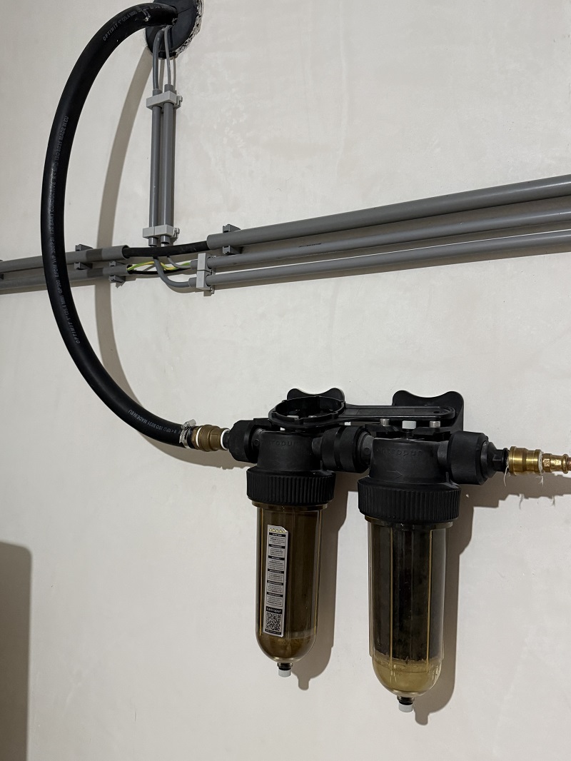 Foto met een systeem dat gemonteerd is aan de muur om met regenwater toilet door te spoelen