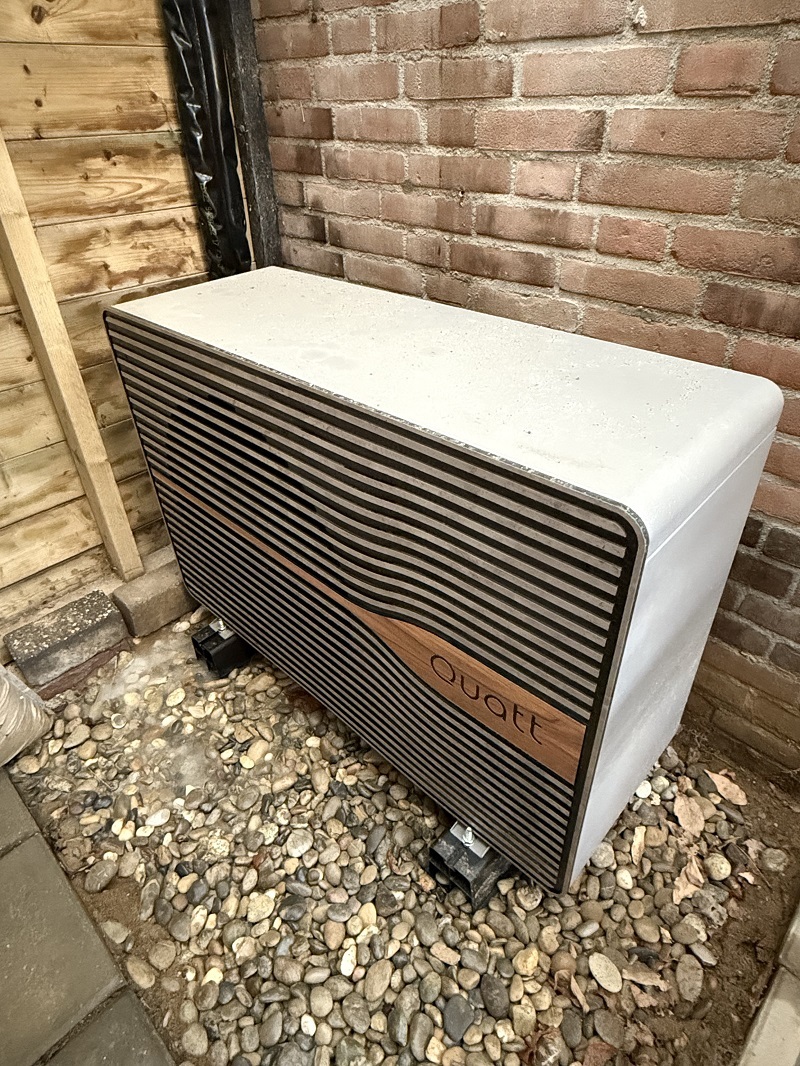 Foto van een warmtepomp die buiten is gemonteerd
