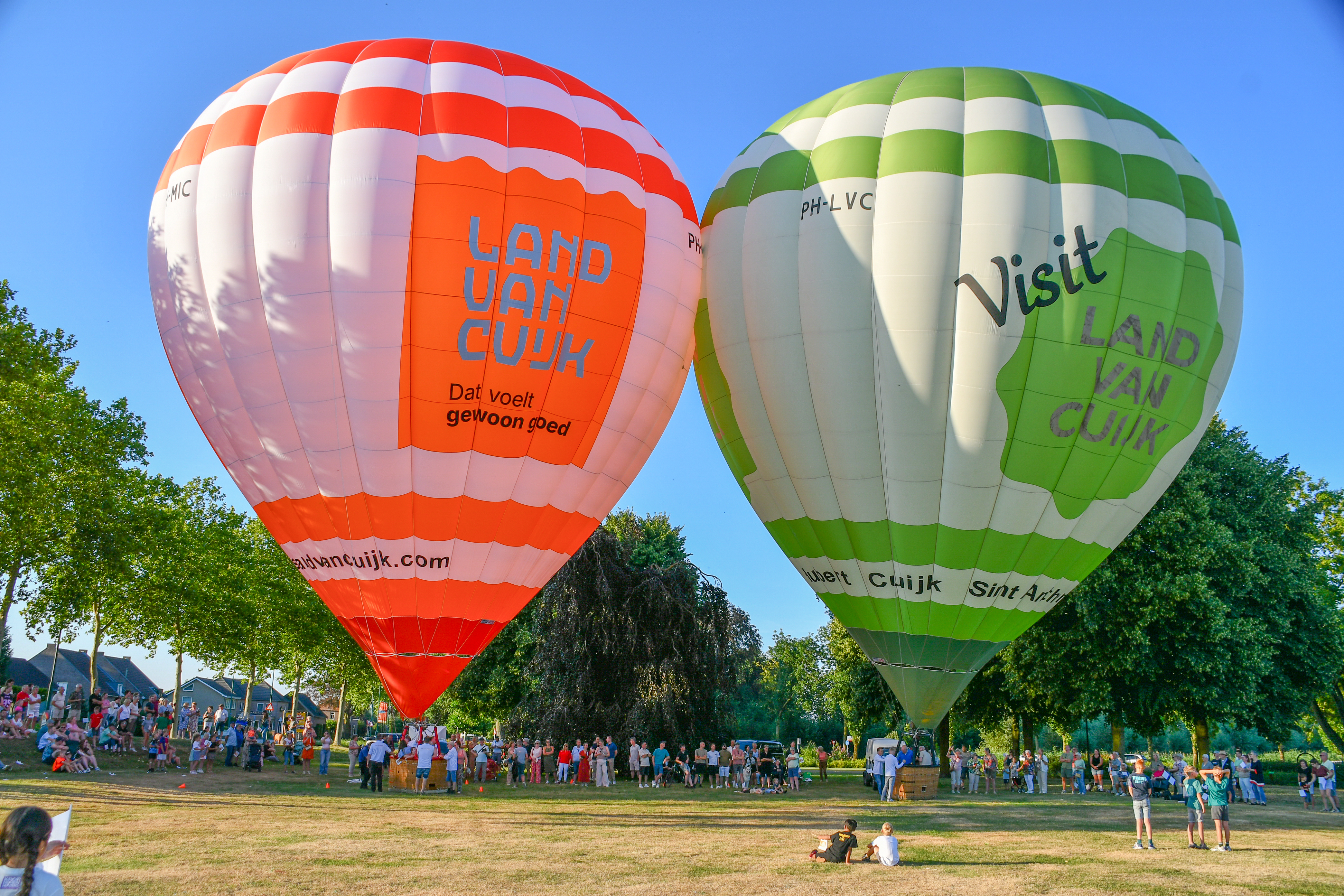 Foto met de 2 nieuwe Land van Cuijk-luchtballonen. De ene is rood-wit en de andere groen-wit.