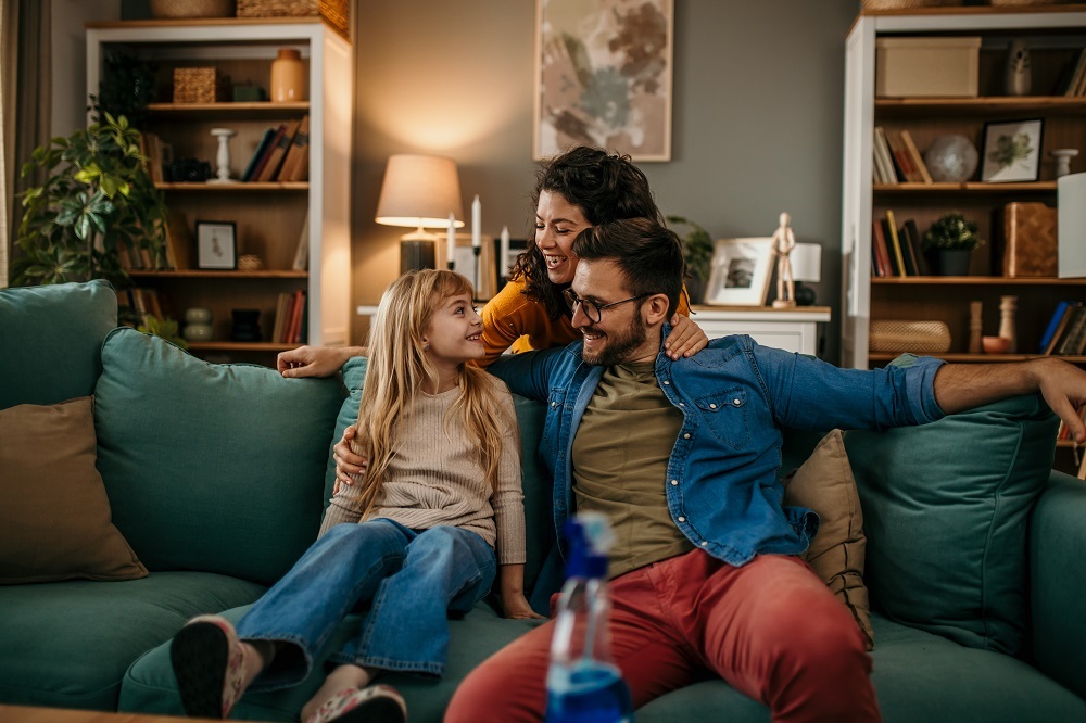 Foto van kind, moeder en vader op een groene bank in een woonkamer